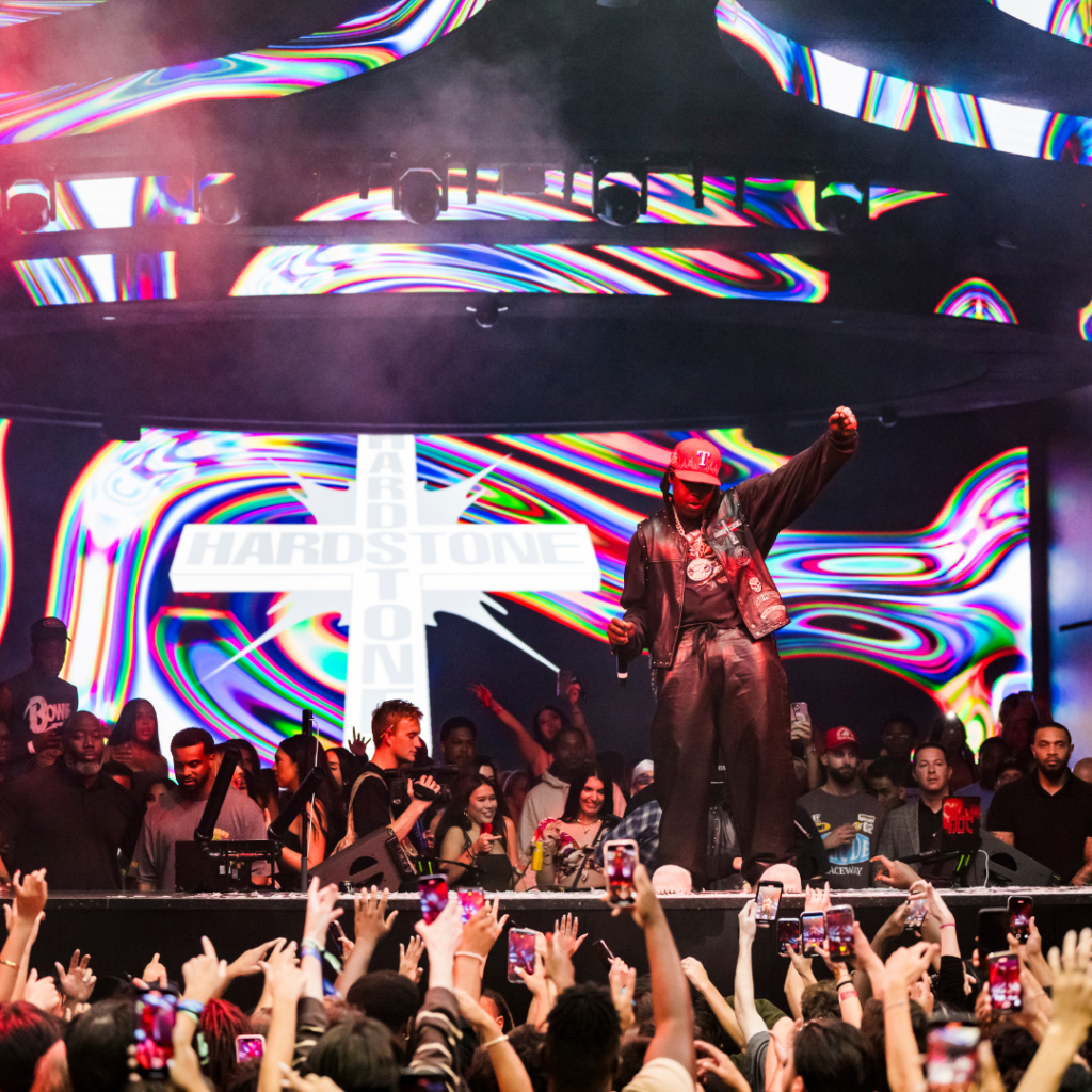 Don Toliver standing on the stage dancing with crowd in front of him and his logo on the LED screen behind him