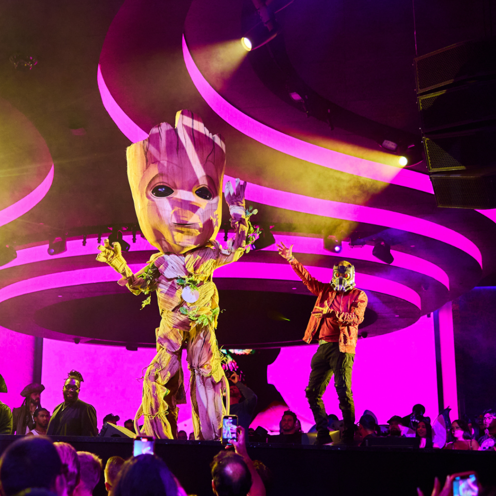 Two costume contestants standing on stage with one dressed as Baby Groot (left) and the other dressed as the Star-Lord (right) from Guardians of the Galaxy 